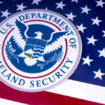 DHS Counterterrorism Official SUSPENDED — Exploitation Scandal…. US Homeland Security emblem over American flag