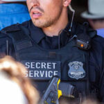 SNAP Cards HACKED—$380 Million Vanished From Families… Secret Service officer wearing tactical gear and radio.