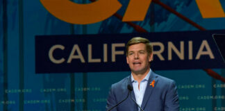 Man speaking at California Democrats State Convention podium.