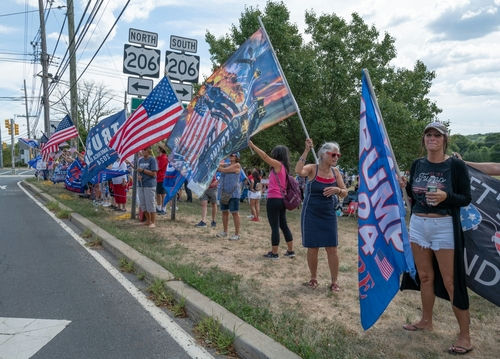 shutterstock2193268111-1jpg group of people holding flags at a roadside rally
