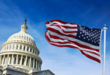 U.S. Capitol building with waving American flag.