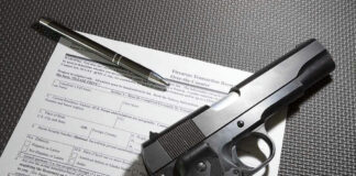 Form with gun and pen on table.