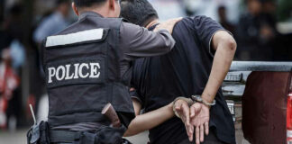 Police officer arresting a person in handcuffs.