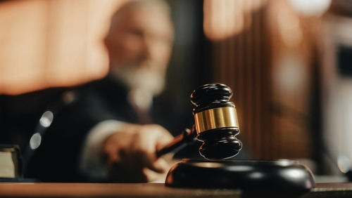 Judge's gavel striking sounding block in courtroom