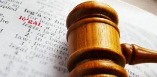 Gavel on book page highlighting the word legal.