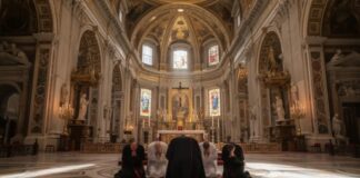 Individuals kneeling in prayer inside a grand cathedral