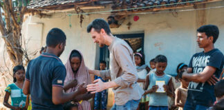 A group of people interacting outdoors in a village.