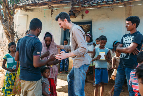 shutterstock_614825171 A group of people interacting outdoors in a village.