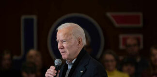 Man speaking into microphone at crowded event.