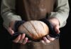 New Food Policing — Checkout Shock Ahead Person holding a freshly baked loaf of bread in a cloth