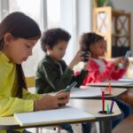 85,000 Kids Vanish — Who Lost Them? Students using smartphones at classroom desks