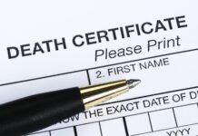 Death certificate form with pen on top.