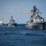 Several naval warships sailing in the ocean.