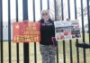 Protester holding fentanyl awareness signs outside White House fence.