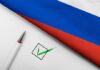 Russian flag, pen, and check mark on paper.